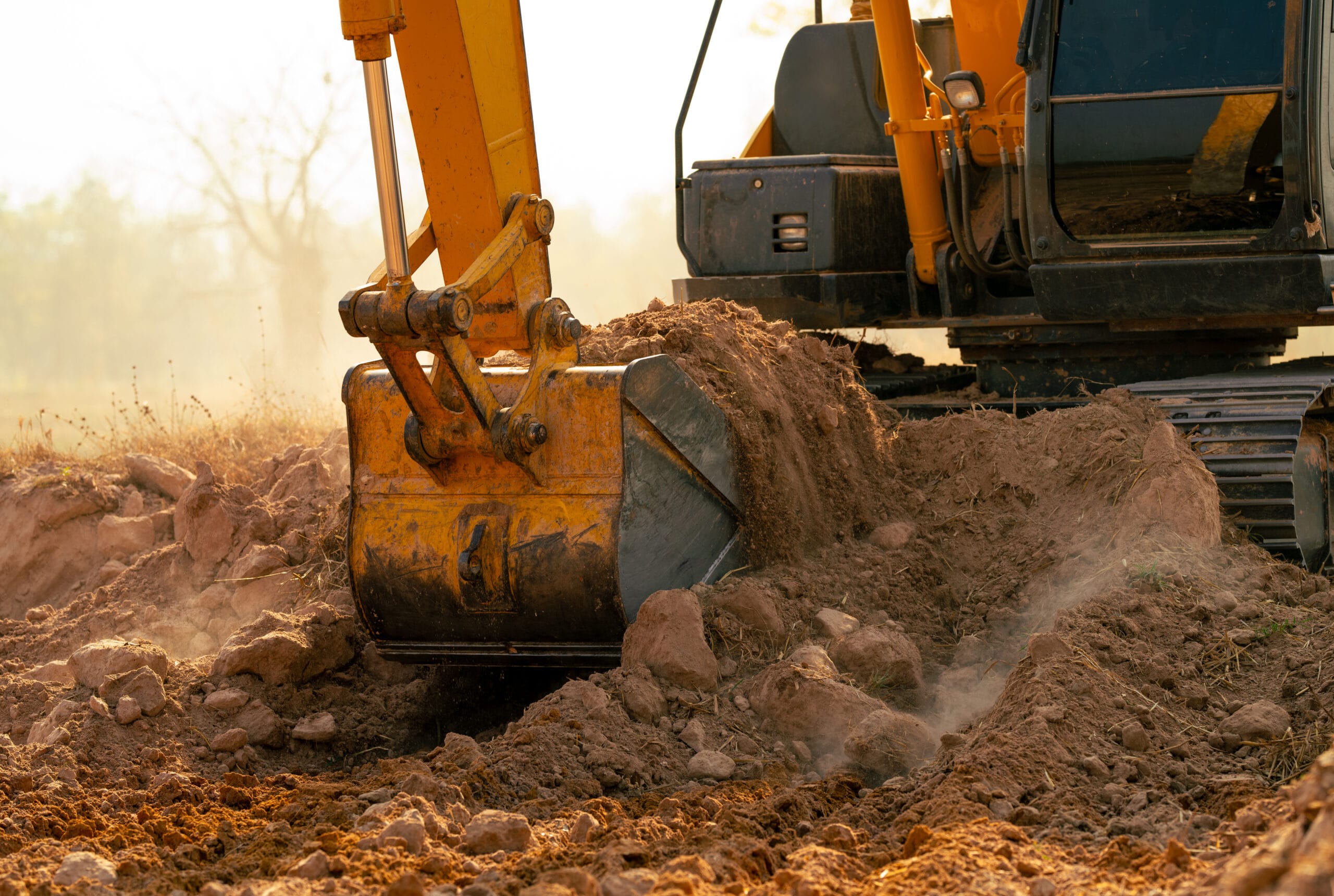 Backhoe working by digging soil at construction site. Crawler excavator digging on demolition site. Excavating machine. Earth moving machine. Excavation vehicle. Construction business.